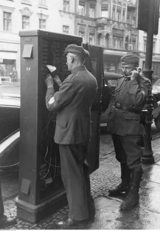 Dwaj niemieccy pracownicy poczty naprawiają uszkodzoną uliczną centralkę telefoniczną w 1939 roku