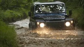 Land Rover Defender brodzi w błocie