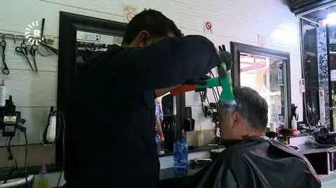 Fryzjer z Kurdystanu z siekierą i młotkiem