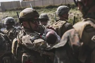 Żołnierze USA w Kabulu. Jeden z nich trzyma w rękach niemowlę