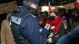 Protest w Katowicach. Policjant legitymuje jedną z uczestniczek