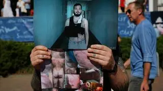 Uczestnicy protestu w Mińsku trzymają zdjęcia ludzi, pobitych przez milicję