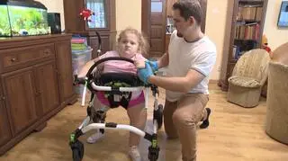 Dziewczynka wymaga regularnej rehabilitacji. Na zdjęciu w towarzystwie fizjoterapeuty
