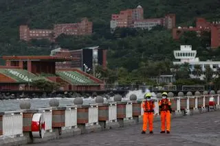 Tajwan. Strażnicy przybrzeżni patrolują okolice falochronu przed nadejściem tajfunu, 11 listopada 2025