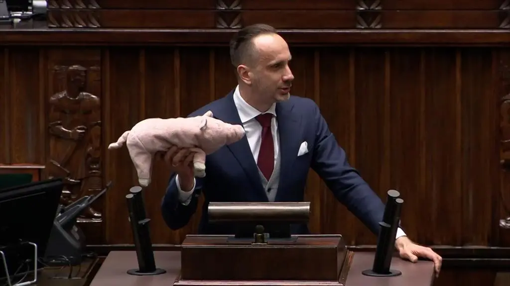 Janusz Kowalski z maskotką świnki 