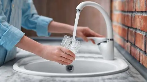 Kobiece-rece-wylewanie-wody-w-szklanym-kubku-shutterstock_470832587