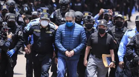 Juan Orlando Hernandez otoczony przez funkcjonariuszy policji podczas procesu ekstradycyjnego w Hondurasie