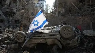 Flaga Izraela wbita w zniszczony samochód po uderzeniu irańskiego pocisku balistycznego w dzielnicy mieszkalnej w Ramat Gan, niedaleko Tel Awiwu