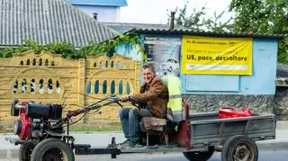 Mężczyzna na tle plakatu partii PAS