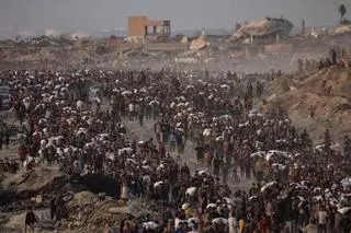 Wysiedleni Palestyńczycy niosą worki z mąką, po tym jak ciężarówki z pomocą humanitarną wjechały do północnej Strefy Gazy 