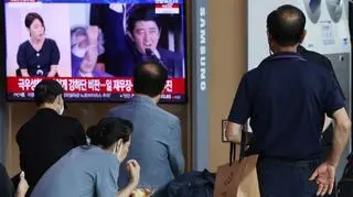 Ludzie oglądają wiadomości o zamachu na byłego premiera Japonii Shinzo Abe