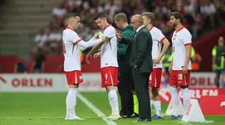 Piotr Zieliński przekazuje opaskę kapitana Robertowi Lewandowskiemu podczas towarzyskiego meczu z Ukrainą