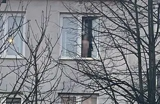 Dzieci stały w oknie na czwartym piętrze 