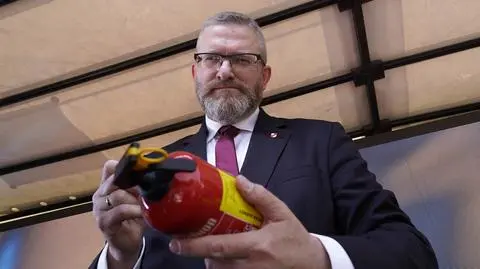 Grzegorz Braun podpisuje gaśnicę