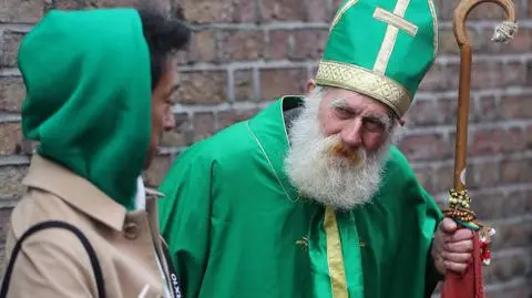 Dzień św. Patryka. Turysta rozmawia z mężczyzną przebranym za św. Patryka w Temple Bar w Dublinie