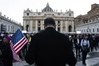 Mężczyzna z amerykańską flagą na placu świętego Piotra
