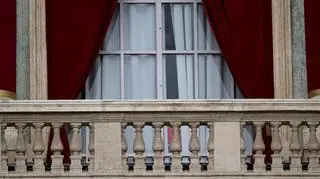 Kardynałowie ledwo widoczni przez okno balkonu z Placu Świętego Piotra