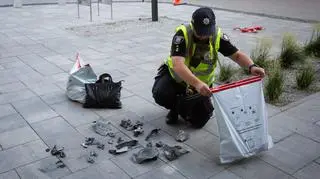 Ukraiński policjant przed blokiem w Kijowie, zaatakowanym przez rosyjskiego drona. Zdjęcie z 13 lipca  