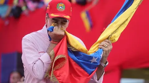 Nicolas Maduro całuje flagę Wenezueli w czasie wiecu w Caracas