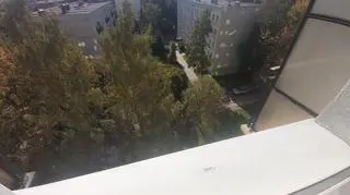 The baby was standing on a windowsill at the fourth floor