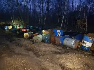 Beczki wyrzucone w przy leśnej drodze