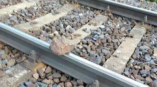 Ktoś układa kamienie na torach kolejowych w okolicach dworca Łódź Chojny