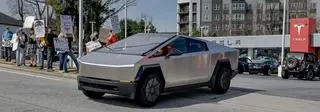 Cybertruck w mieście Decatur w stanie Georgia. W tle protestujący sprzeciwiający się działaniom Elona Muska