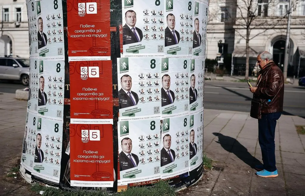 Mężczyzna przygląda się plakatom wyborczym w Sofii