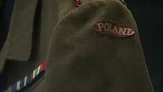  Na naramiennikach widoczne są oznaczenia stopnia kaprala podchorążego, na rękawach zaś naszywki "POLAND"