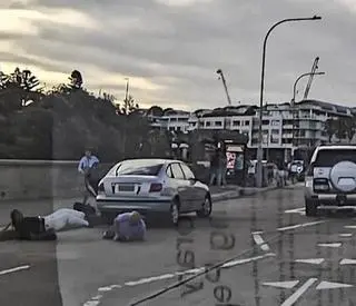 Próba powstrzymania terrorysty. Widzimy, jak mężczyzna w różowej koszuli powalił napastnika na ulicę. Sam też upadł. 