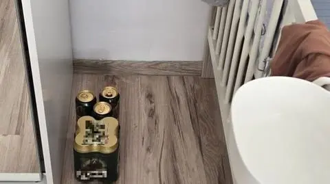 Puszki i butelki po alkoholu w pobliżu łóżeczka dziecka