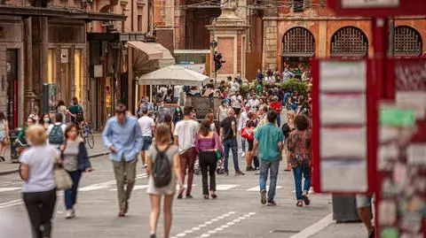 shutterstock_2578148417 Bolonia, Włochy 1 stycznia 2025: Turyści i mieszkańcy spacerujący po via rizzoli, głównej ulicy w bolonii, w pobliżu przystanku autobusowego