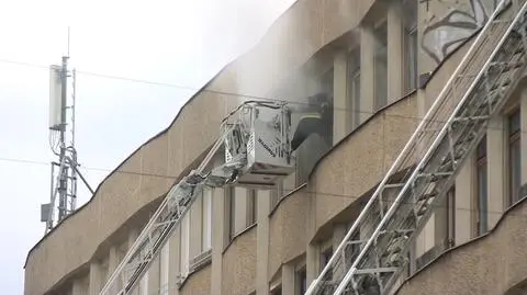 Dym nad budynkiem, za plecami strażackie syreny. Pożar przerwał konferencję posła