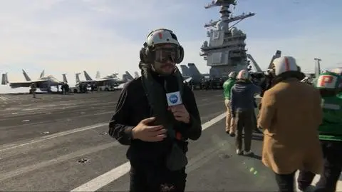 Reporter TVN24 Artur Molęda w hangarze F/A-18 Super Hornet na lotniskowcu USS Gerald Ford