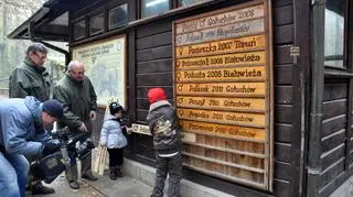 Olga i Filip Fabijańscy umieszczają tabliczkę z imieniem żubra