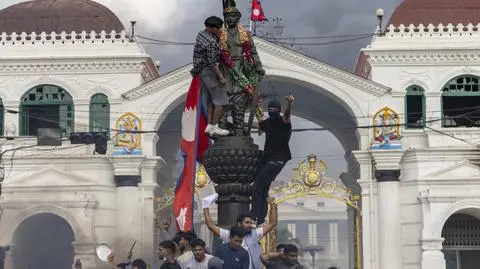 Protestujący wieszają flagę narodową podczas demonstracji w Katmandu. Zdjęcie z 9 września