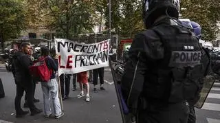 Policja i protestujący z plakatem "Macron, jesteś następny" w Paryżu