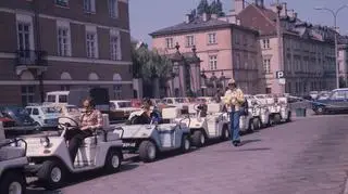 Warszawa 1977, Warszawskie Przedsiębiorstwo Turystyczne Syrena organizuje zwiedzanie miasta samochodami fiat, zakrytymi i odkrytymi oraz melexami, w cenie 7 zł za kilometr lub 140 zł za godzinę. Na zdjęciu melexy na ul. Podwale