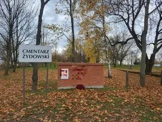 Swastyki namalowano na murze i tablicy upamiętniającej macewy