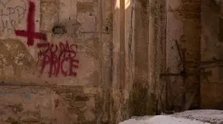 Obok odwróconego krzyża jest nazwa zespołu zapisana z błędem