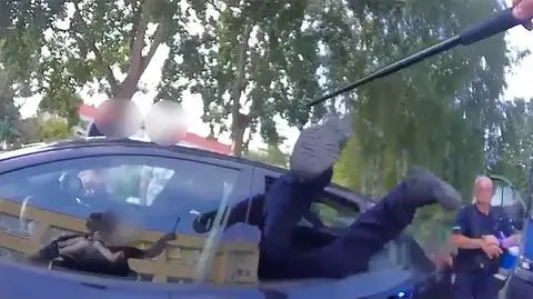 Policjant wchodzi do auta