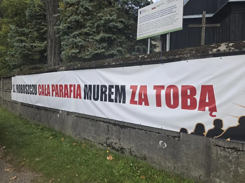 Baner przed kościołem w Grojcu