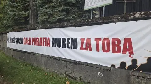 Baner przed kościołem w Grojcu