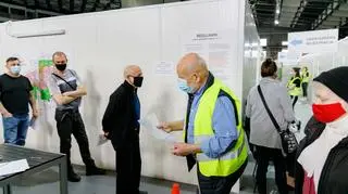 Wielu pacjentów czuje się niepewnie, są zagubieni w nieznanym miejscu. Wolontariusz powinien to wyczuć. Kobiecie w czerwonej maseczce pomoże wypełnić formularz, wskaże wieszak na kurtkę i miejsce w kolejce.