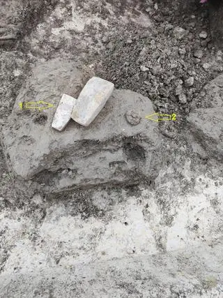 Przy szkielecie dziecka znaleziono krzemienną siekierkę (po lewej) oraz bursztynową plakietkę 