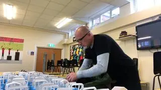 Zane Powles przygotowuje paczki żywności dla swoich uczniów