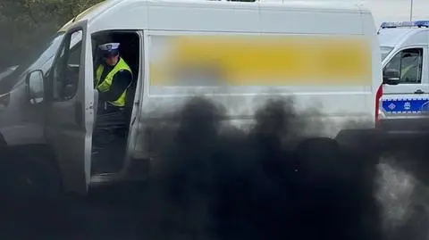 Z rury wydechowej wydobywał się czarny, gęsty dym. Za nim jechali policjanci