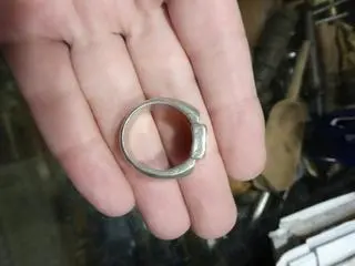 Pierścień wykonano ze srebra. Liternictwo jest zaś złote