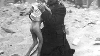 Policjant wynoszący dziewczynkę z miejsca katastrofy budowlanej w Warszawie, 1932