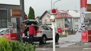 Wiceminister sportu Jacek Osuch tankuje benzynę do kanistrów